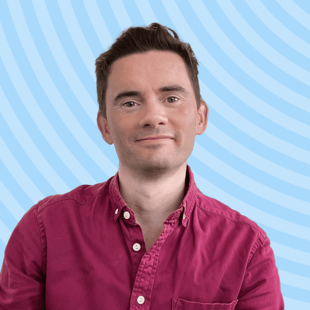 Matt, a white male wearing a red shirt, posed against a blue background.