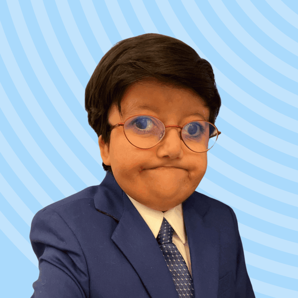 Hamza, Asian male wearing a suit and glasses, posed against a blue background.