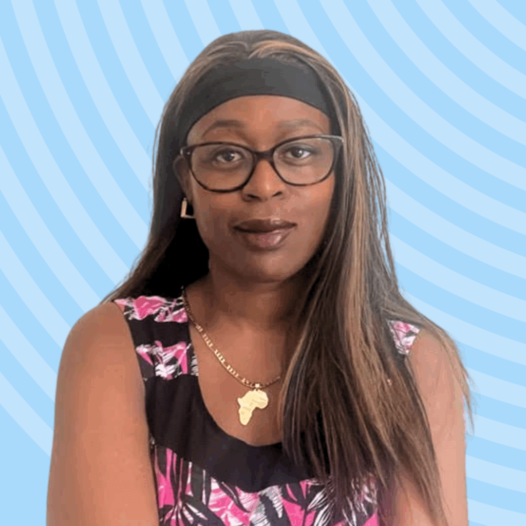 Dolapo, a Black woman with long hair, wearing glasses and a top with an African map neckline, posed against a blue background.