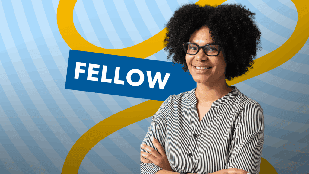 A black woman teachers with the 'Fellow' in the background